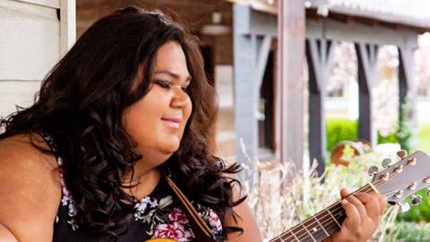 Singer/songwriter Mel Soul playing the guitar.