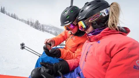 Guests looking at a phone on a chairlift
