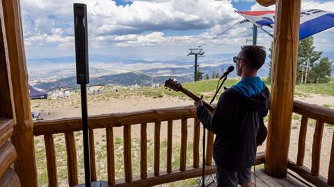 Musician singing on the deck of Snowshoe Tommy's in the summer.