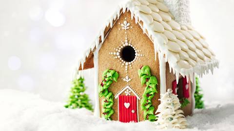 Gingerbread house covered in white frosting.