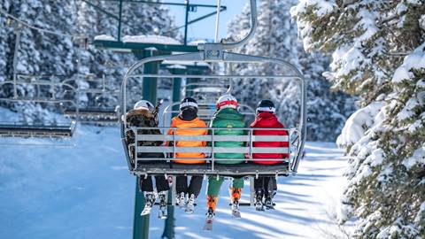 Deer Valley Ski Instructor sitting on a chairlift with guests.