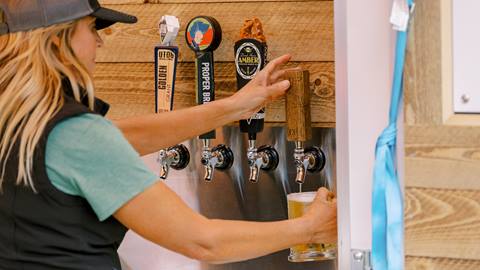 Bartender serving beer from tap.