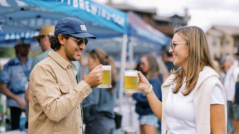 Couple holding Deer Valley Mountain Beer Festival glasses