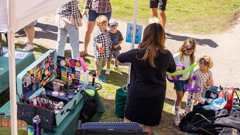 A woman entertaining children at the Kid's Zone.