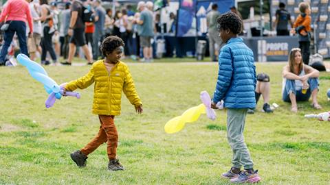 Two boys playing with balloon shapes at Deer Valley Mountain Beer Festival.