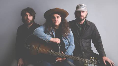 Michelle Moonshine band members sitting on a bend together.