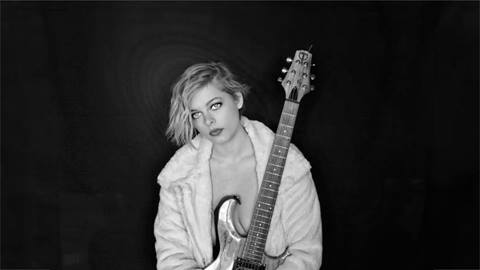 Singer, River Arrow, holding guitar in a black and white image.