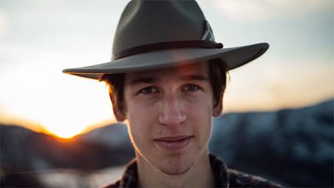 Musician Wyatt Pike looking at the camera with a sunset in the background.