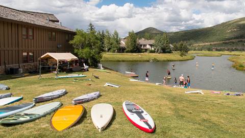 Stand-up paddleboards at the edge of a pond.