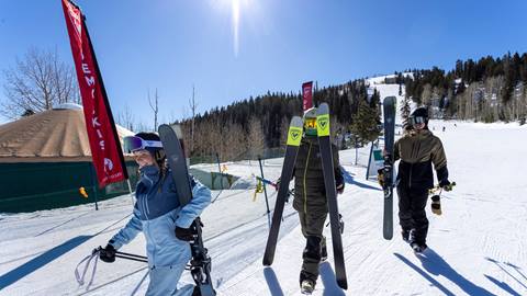 Deer Valley guests walking with demo skis outside of the Rossignol High Performance Test Center.