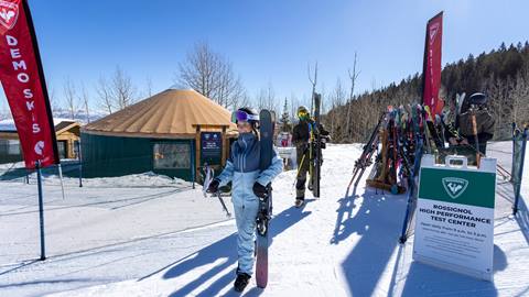 Deer Valley guests walking with demo skis outside of the Rossignol High Performance Test Center.