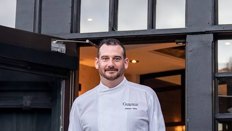 Professional headshot of Chef Clement Gelas standing in doorway of restaurant