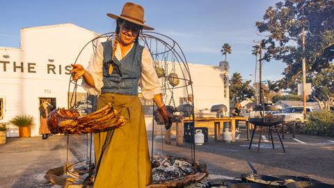 Chef Sarah Glover holding ribs that were cooked over an open fire.