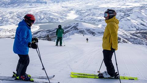 Ted Ligety standing with a skier on the mountain at Deer Valley.