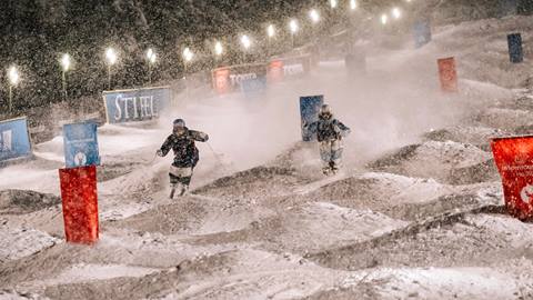 Two athletes competing in dual moguls in the snow at Deer Valley World Cup.