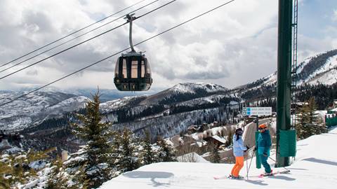 Skiers standing in front of gondola.