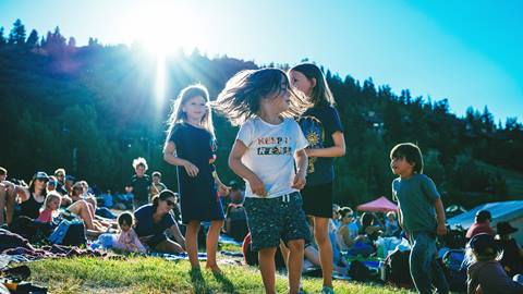A group of young kids are playing together at a Deer Valley summer concert.