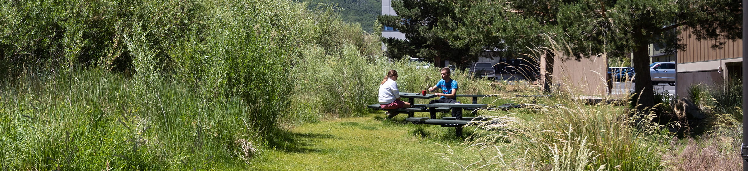 Two employees sitting at a picnic table outside of Deer Valley staff housing.