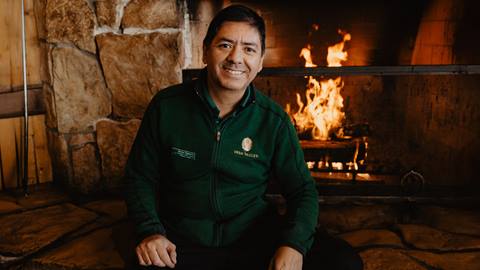 Deer Valley lodge attendant sitting in front of fireplace.