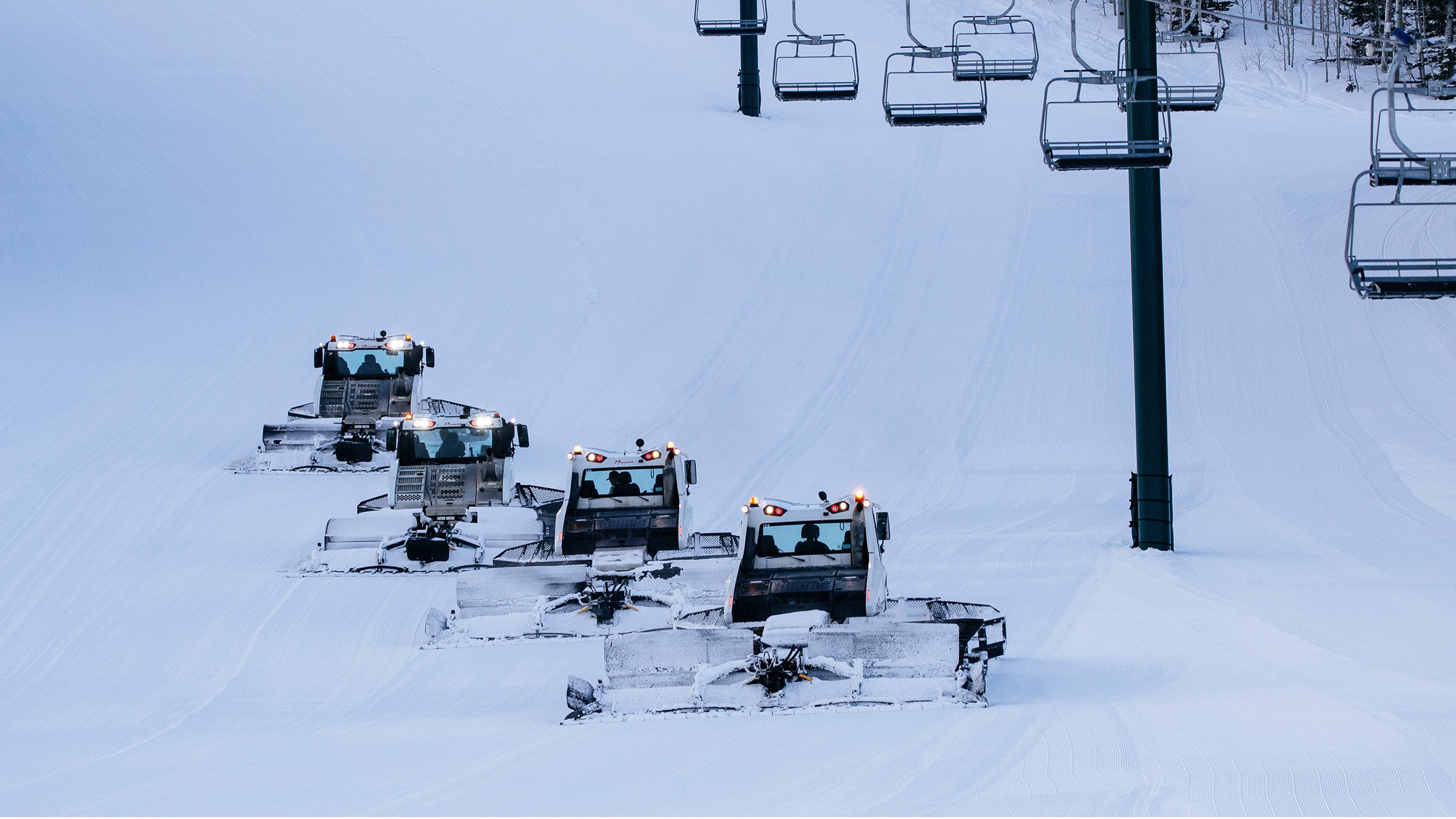 Group of snowcats grooming Deer Valley ski run.