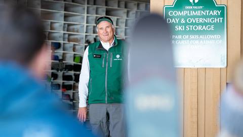 Deer Valley staff member standing at complimentary ski storage.