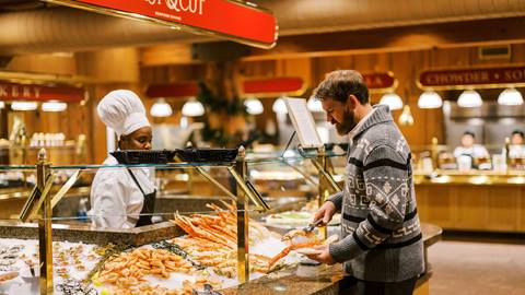 Man serving himself at raw bar at Cast & Cut | Seafood Dining.