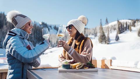 Two women drinking wine outside Deer Valley's après-ski yurt, Chute Eleven.