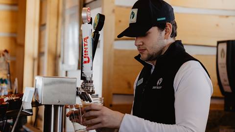 Deer Valley Staff pouring beer from tap at Cushing's Cabin.