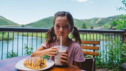 Girl eating lunch at Deer Valley Cafe on the deck in the summer.