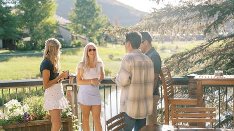 Guests chatting on Deer Valley Cafe deck during the summer at Deer Valley.