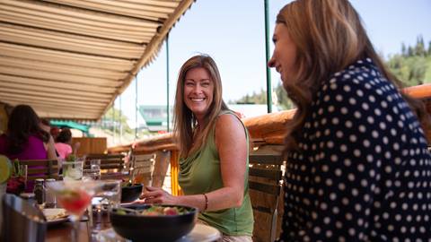 Two guests sitting on the Royal Street Cafe deck for lunch during the summer.