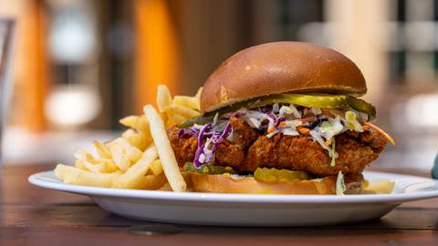 Fried Chicken sandwich and fries served on a white plate.