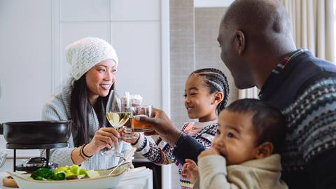 A family of four eating a meal together.