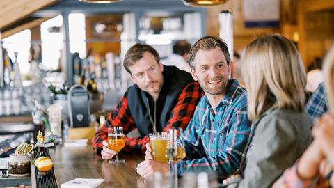 Guests sitting at the bar talking at the Sticky Wicket.