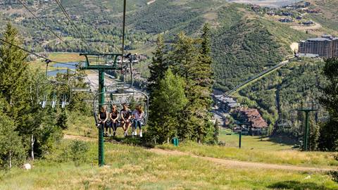 Four guests riding chairlift at Deer Valley in the summer.