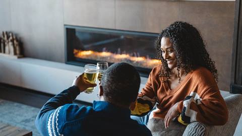 Couple drinking wine on couch.