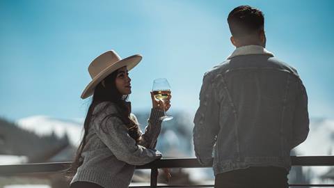 Couple drinking wine on private deck at Deer Valley lodging property in the winter.