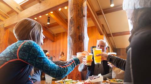 Guests doing a cheers with beer in Snow Park Lodge.