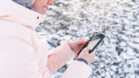 Woman using the Deer Valley App on a chairlift in the winter.