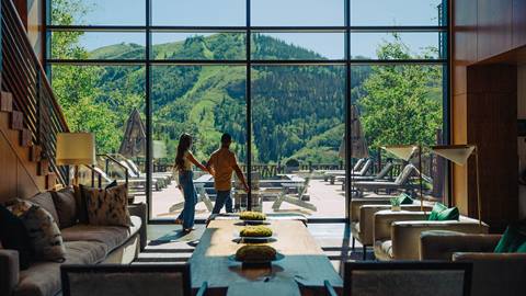 Couple holding hands walking through One Empire Pass lodging property