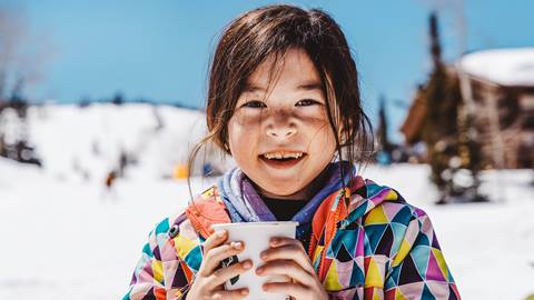 Young girl drinking hot chocolate.