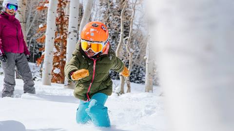 Young boy running in the snow.