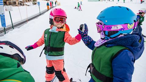 Deer Valley ski school students giving high five.