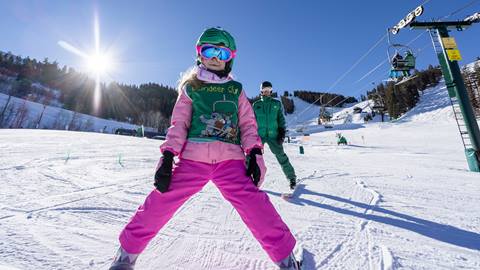 Deer Valley ski instructor teaching young girl to ski.