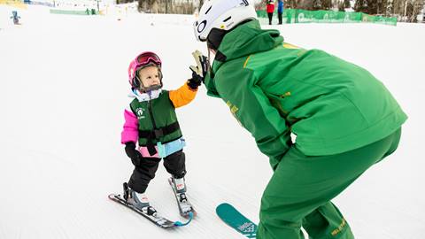 Deer Valley ski instructor giving girl a high five.