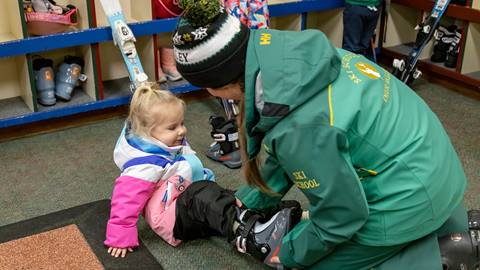 Deer Valley ski instructor helping girl get ready for her ski lesson.