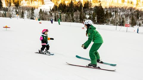 Deer Valley ski instructor teaching young girl to ski.