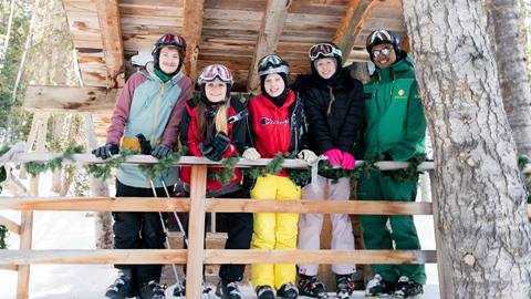 Group of teenagers smiling with a Deer Valley Ski Instructor.