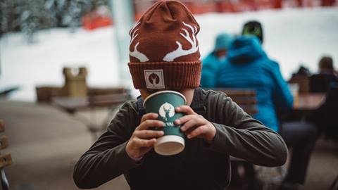 Boy wearing antler beanie and drinking Deer Valley hot chocolate.