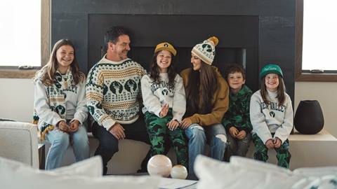 Family sitting in front of fireplace wearing the Deer Valley Legacy Collection.